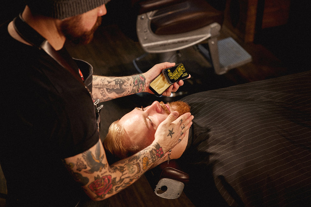 Barber applying Dick Johnson Snake Balm to customers beard.